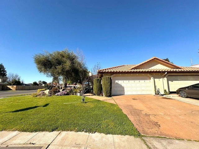 view of front of house featuring a tiled roof, concrete driveway, a front yard, stucco siding, and a garage