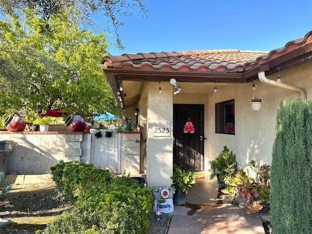 doorway to property featuring stucco siding and a tiled roof