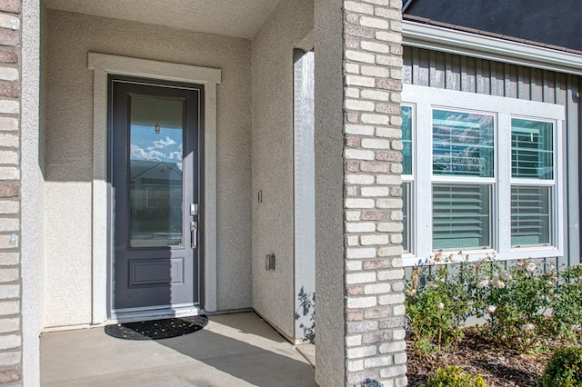 doorway to property featuring stucco siding