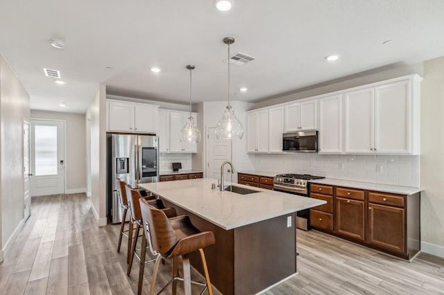 kitchen featuring a sink, visible vents, light wood-type flooring, and appliances with stainless steel finishes