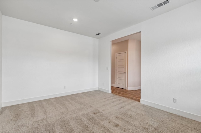 empty room with carpet flooring, baseboards, and visible vents