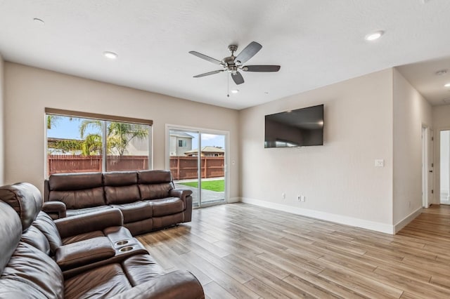 living area featuring recessed lighting, a ceiling fan, light wood-type flooring, and baseboards