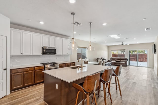 kitchen with tasteful backsplash, visible vents, stainless steel appliances, and a sink