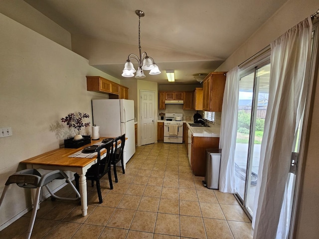 kitchen featuring white appliances, lofted ceiling, light tile patterned flooring, a sink, and under cabinet range hood