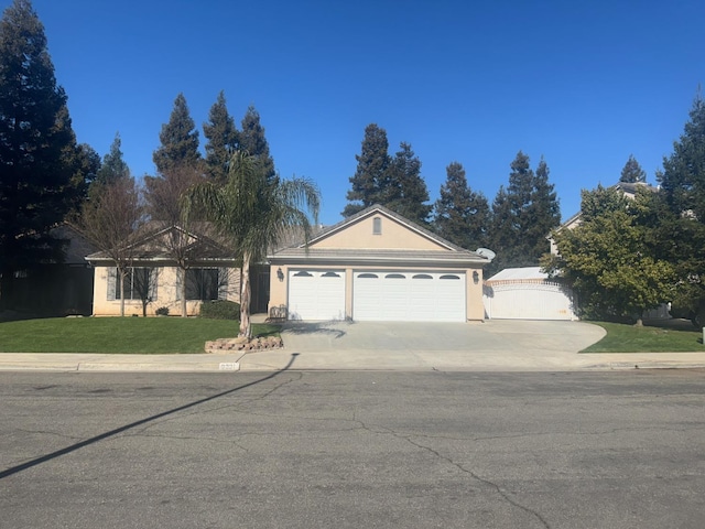 view of front facade featuring a front lawn, fence, stucco siding, a garage, and driveway