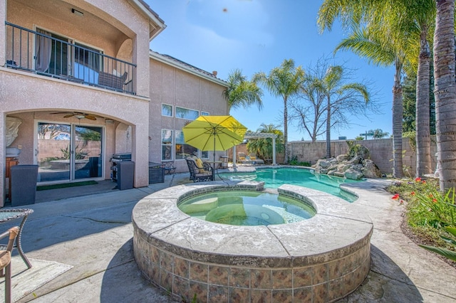 view of swimming pool featuring a patio area, a pool with connected hot tub, a ceiling fan, and a fenced backyard