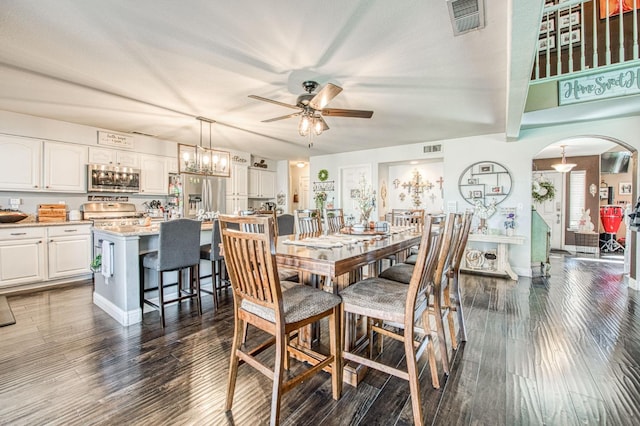 dining room with visible vents, arched walkways, dark wood finished floors, and ceiling fan with notable chandelier