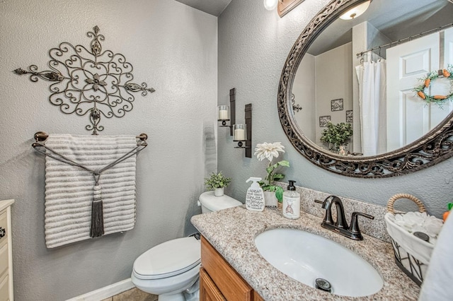 bathroom featuring a shower with curtain, toilet, vanity, and a textured wall