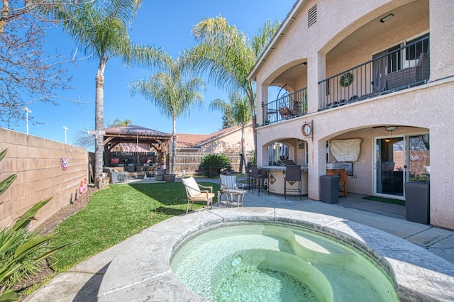 view of swimming pool featuring a gazebo, an in ground hot tub, outdoor dry bar, and a patio