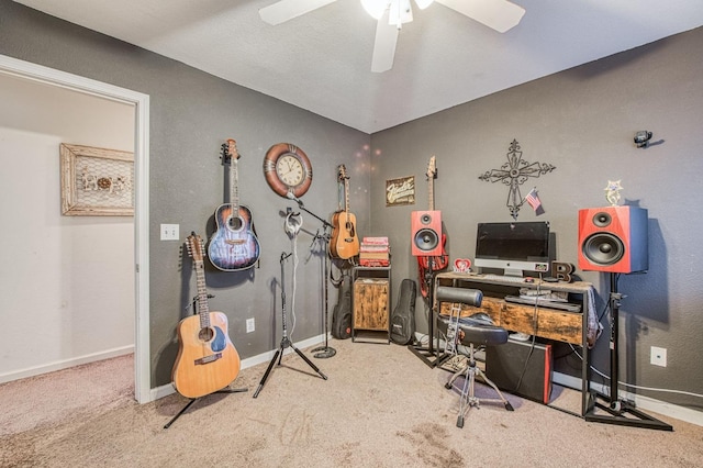 carpeted office space featuring a ceiling fan and baseboards