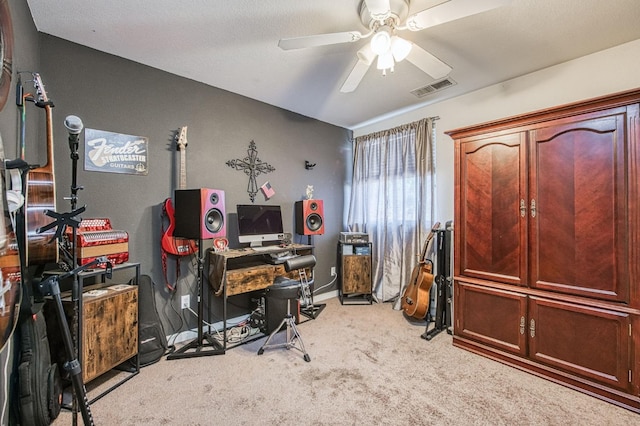 office area with visible vents, light carpet, baseboards, and a ceiling fan