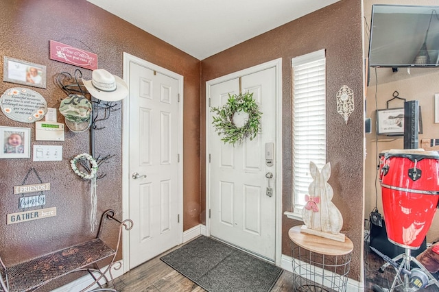 foyer entrance featuring baseboards and wood finished floors