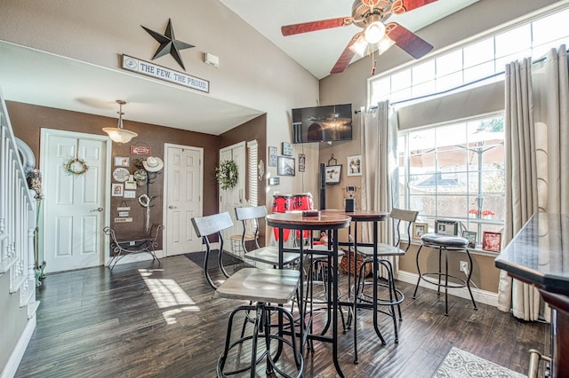 dining area with baseboards, lofted ceiling, dark wood-type flooring, and ceiling fan