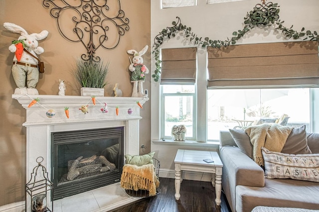 sitting room featuring a glass covered fireplace, wood finished floors, and baseboards