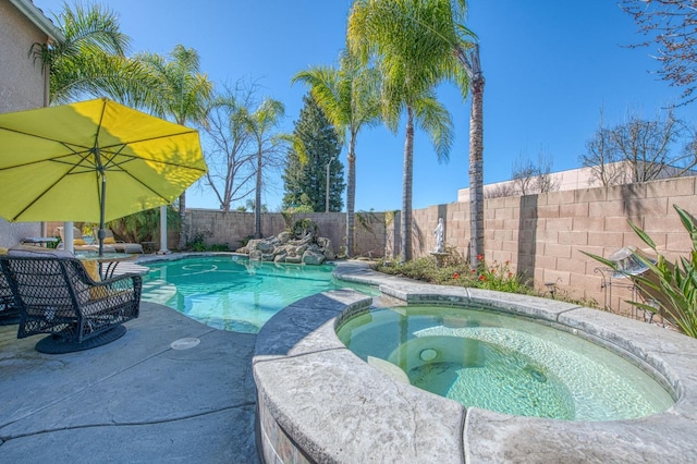 view of pool featuring a fenced backyard and a pool with connected hot tub