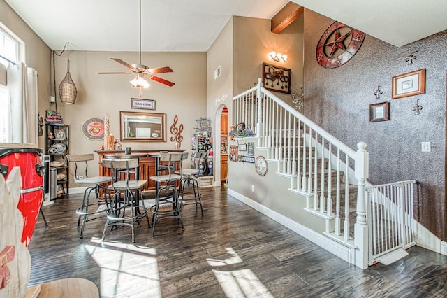 dining room featuring baseboards, arched walkways, wood finished floors, and stairway