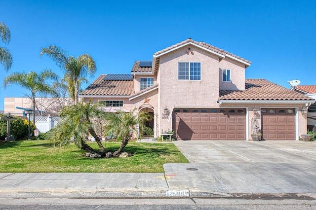 mediterranean / spanish-style house with a front lawn, fence, concrete driveway, a tile roof, and stucco siding