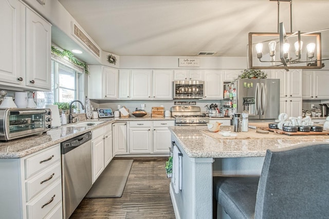 kitchen with visible vents, a toaster, a sink, stainless steel appliances, and white cabinets