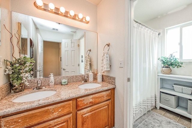 full bath featuring double vanity, visible vents, and a sink