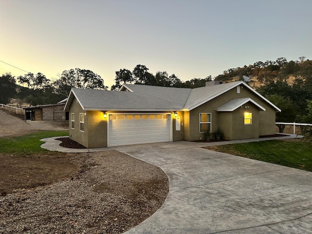 single story home with concrete driveway, a garage, and stucco siding