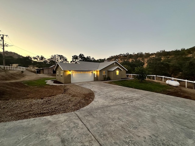 view of front facade featuring a front yard, fence, a garage, and driveway