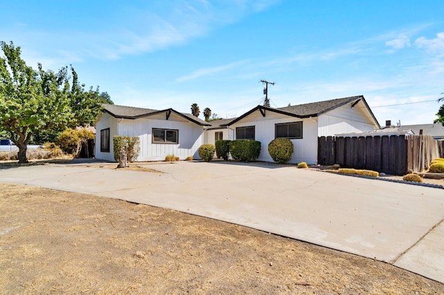 view of front facade with concrete driveway and fence