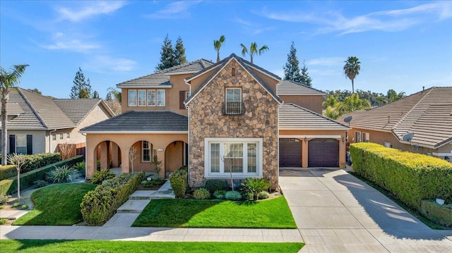 view of front of home featuring a garage, concrete driveway, a front lawn, and stucco siding