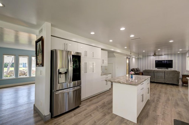 kitchen with open floor plan, visible vents, stainless steel fridge, and light wood finished floors