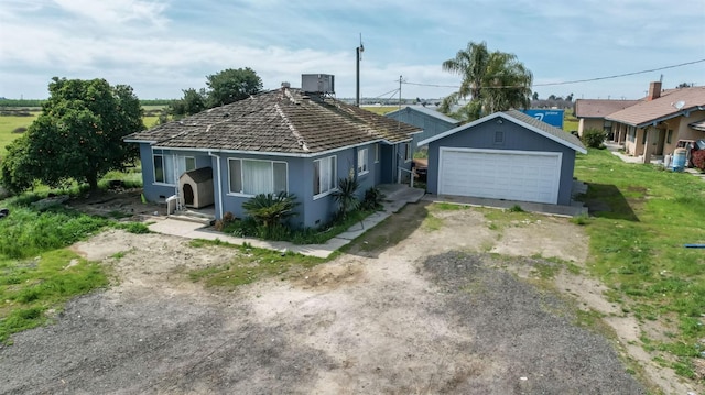 view of front of property with stucco siding, a garage, an outdoor structure, and a front lawn