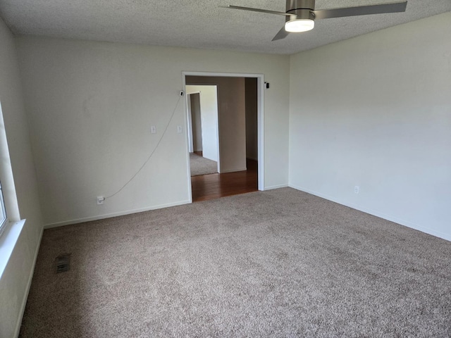 spare room with visible vents, a ceiling fan, a textured ceiling, carpet floors, and baseboards