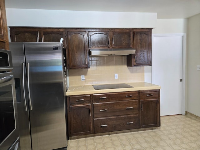 kitchen featuring under cabinet range hood, light countertops, light floors, and appliances with stainless steel finishes