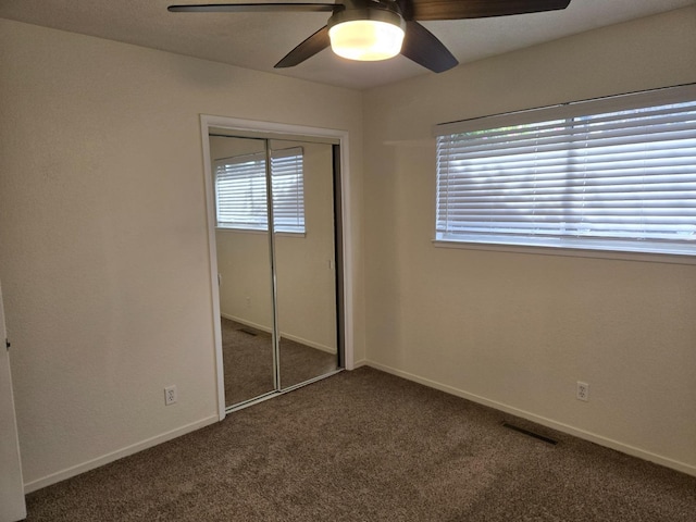 unfurnished bedroom featuring visible vents, ceiling fan, baseboards, carpet, and a closet