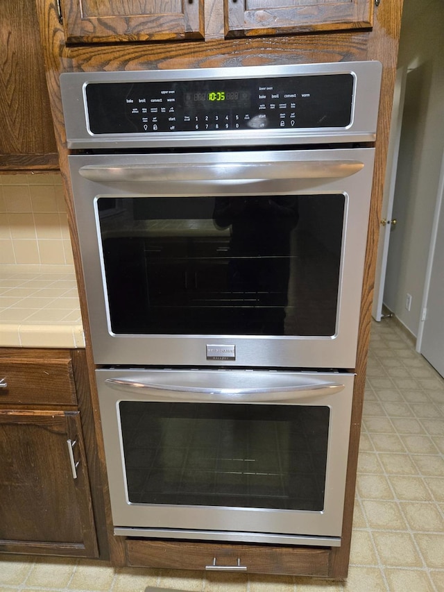 room details featuring decorative backsplash, double oven, and tile countertops