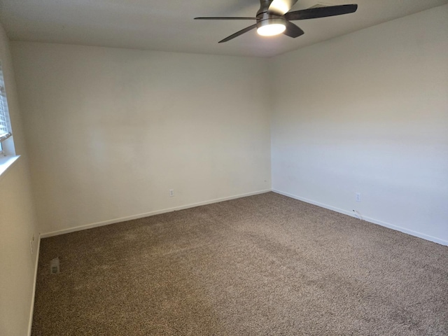 carpeted empty room with a ceiling fan and baseboards