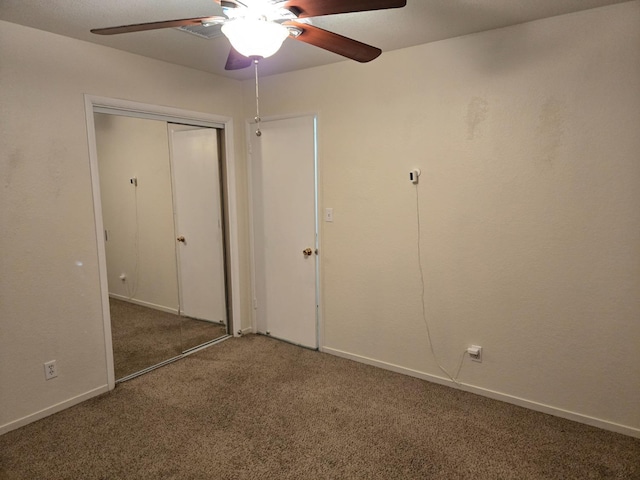 unfurnished bedroom with a closet, ceiling fan, baseboards, and carpet