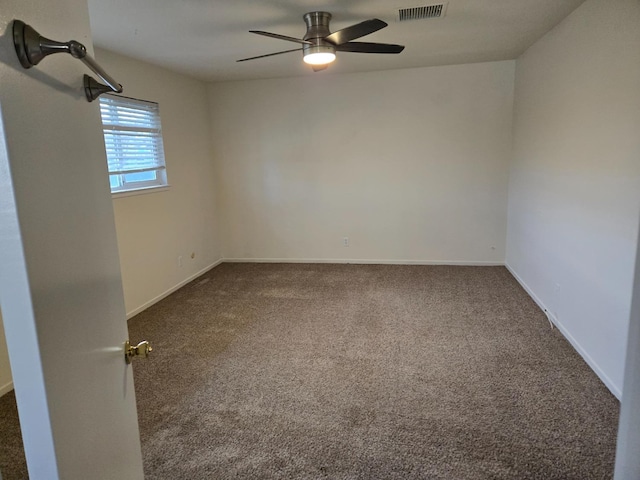 empty room with visible vents, baseboards, ceiling fan, and dark carpet