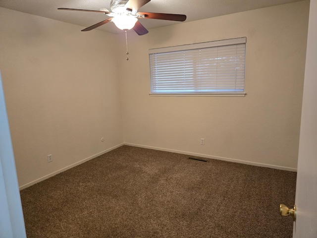 carpeted empty room featuring visible vents, a ceiling fan, and baseboards