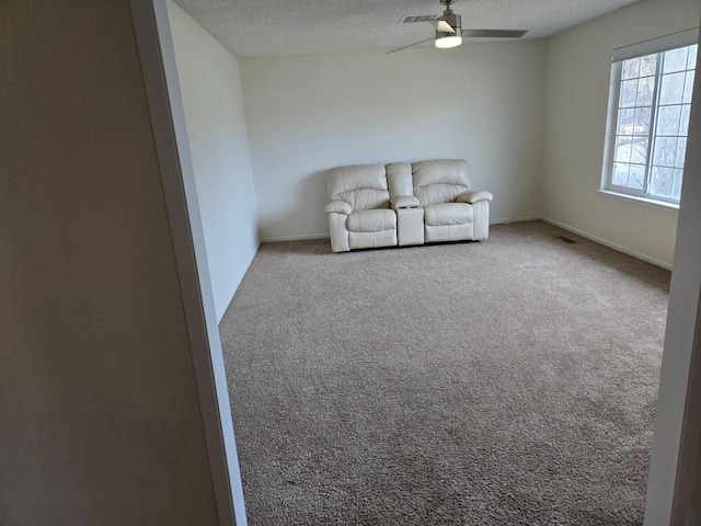 unfurnished room with visible vents, baseboards, ceiling fan, carpet flooring, and a textured ceiling