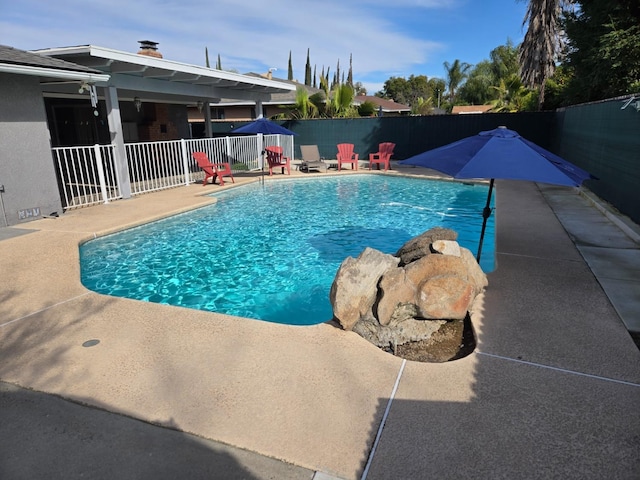 view of swimming pool featuring a patio area, a fenced in pool, and fence