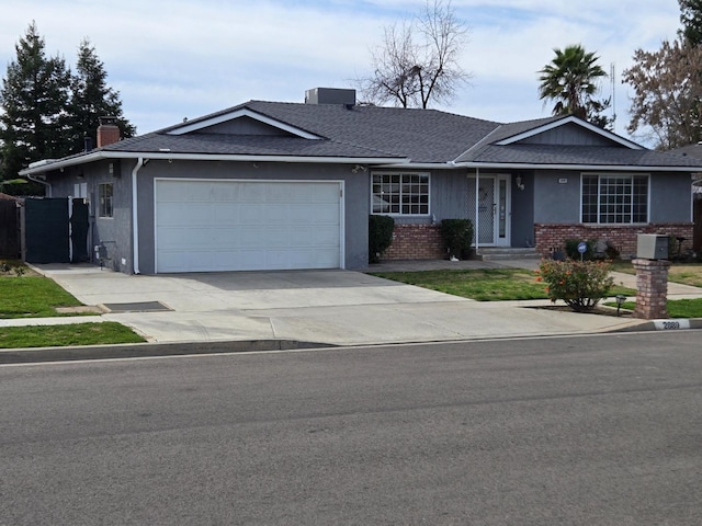 single story home with concrete driveway, an attached garage, brick siding, and a chimney