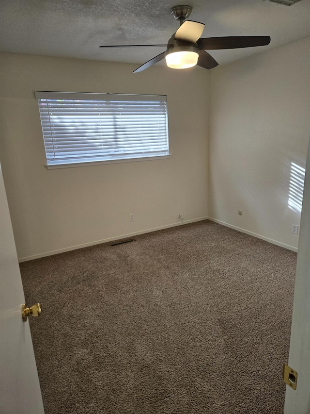 empty room featuring baseboards, a textured ceiling, carpet, and a ceiling fan