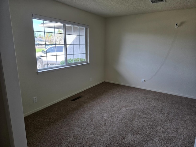 unfurnished room featuring baseboards, visible vents, a textured ceiling, and carpet