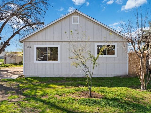 view of property exterior featuring a lawn and fence