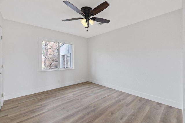 spare room with ceiling fan, baseboards, and light wood-style flooring