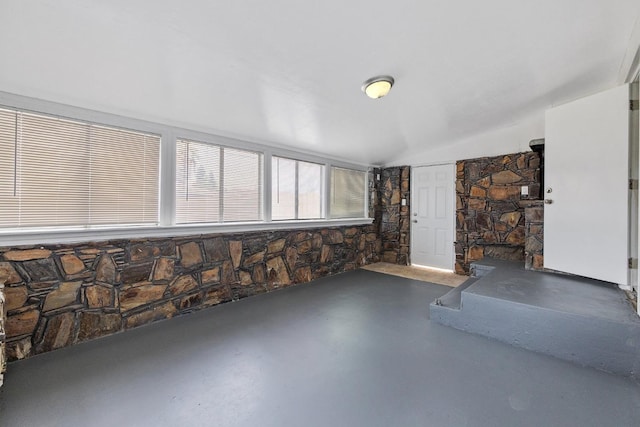 interior space featuring lofted ceiling and concrete flooring