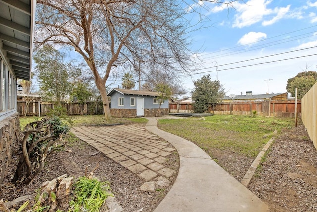 view of yard with a patio, an outdoor structure, and a fenced backyard