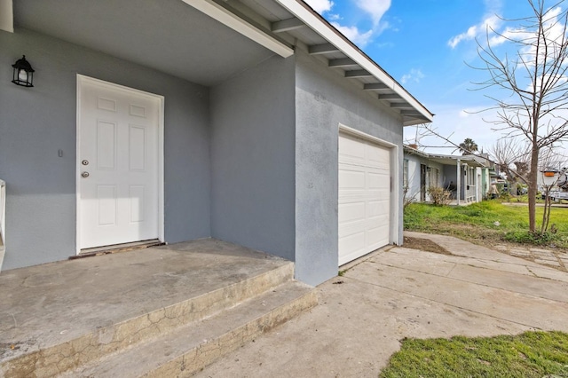 entrance to property featuring stucco siding and an attached garage