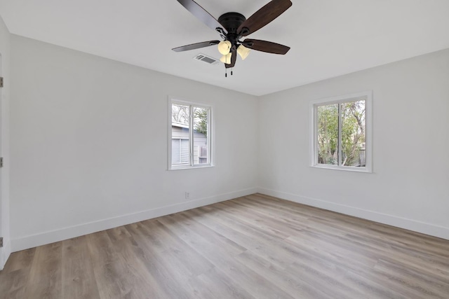 empty room featuring visible vents, baseboards, light wood-style floors, and a healthy amount of sunlight