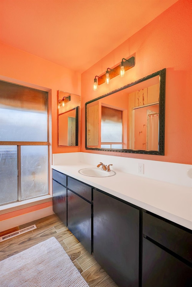 bathroom with wood finish floors, visible vents, and vanity