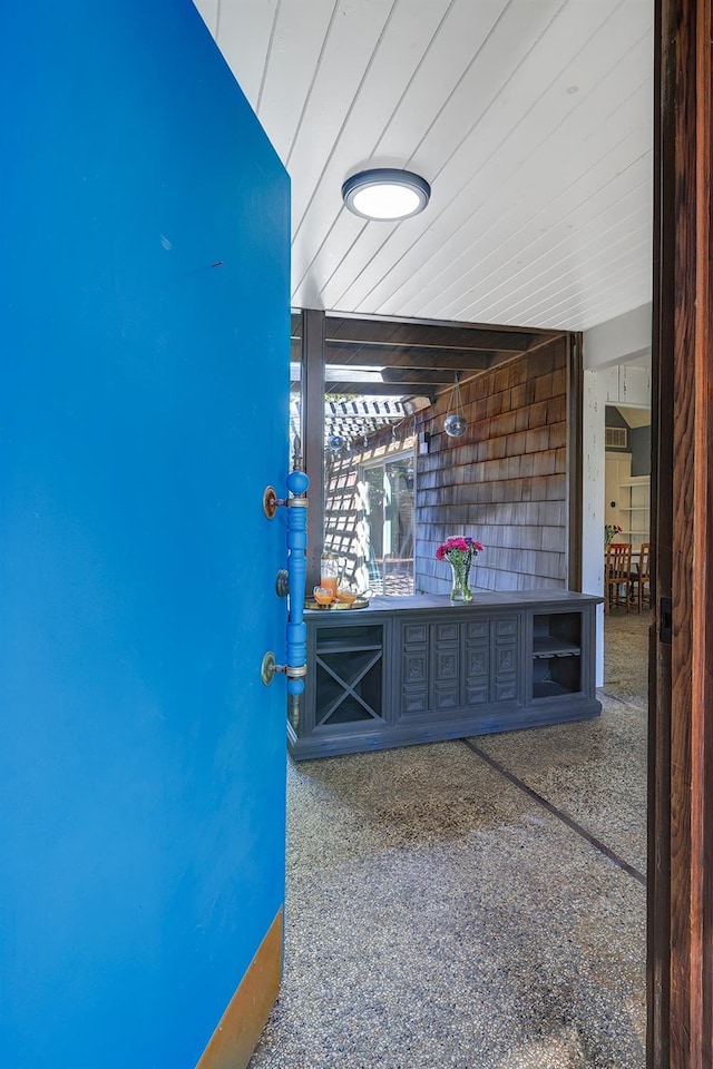 interior space with wood ceiling and speckled floor